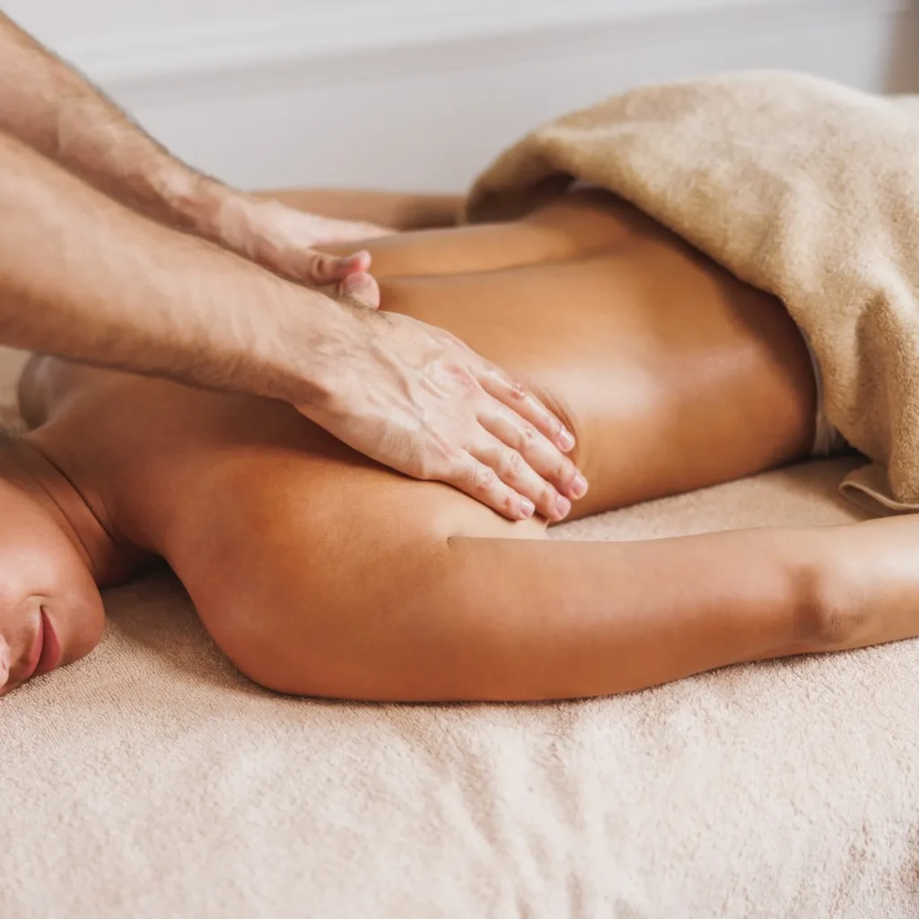 close up of a massage therapit's hands offering a back massage to female patient